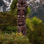 Een traditionele Pou Whenua-houten paal met Whakairo-houtsnijwerk uit de Māori-cultuur.