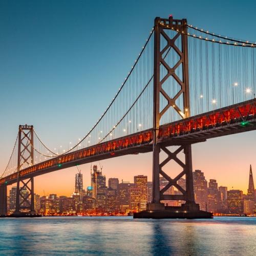Oakland Bay Bridge en San Francisco skyline bij schemering